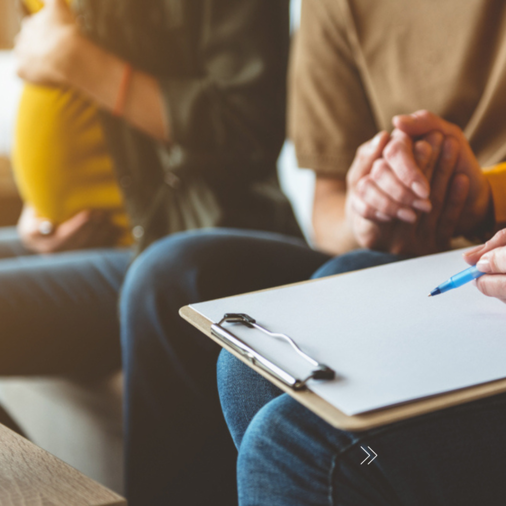 Couple holding hands and reviewing a surrogacy document.