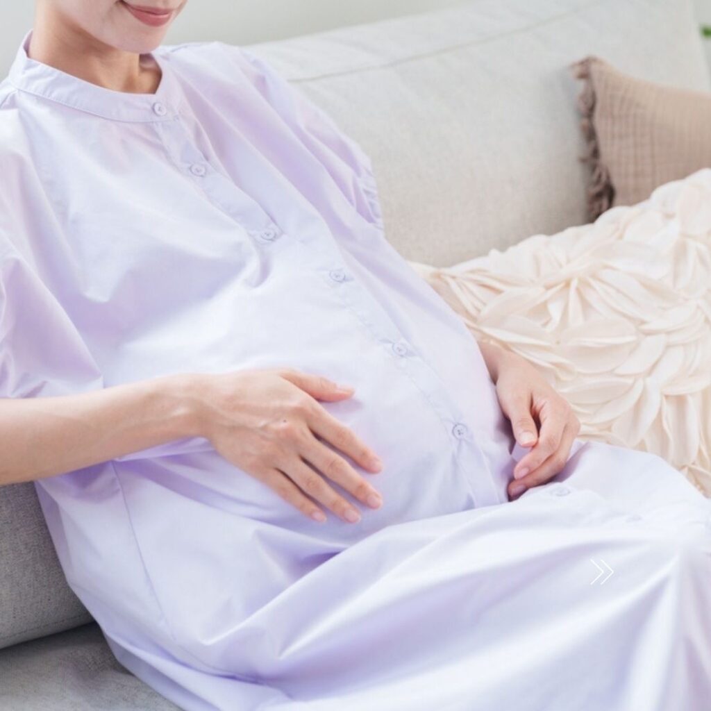 An older pregnant woman holding her belly.