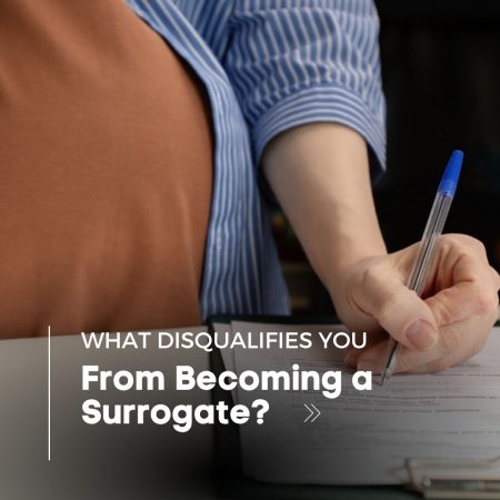 A pregnant woman with a pen in her hand filling out a form.